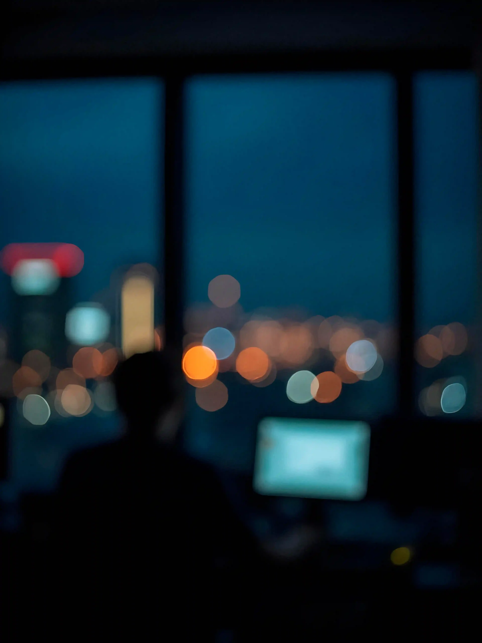 Silhouette working at a desk with city lights in background representing focused SEO strategy and execution process